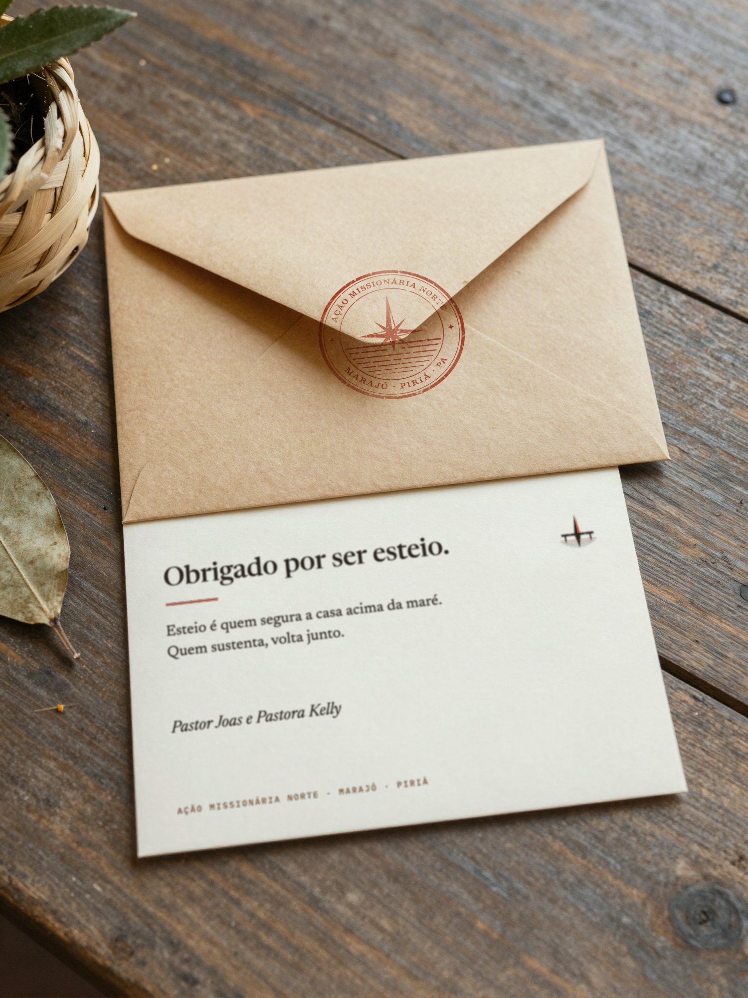 Envelope kraft lacrado com o selo 04 carimbado em Zarcão e cartão creme de agradecimento ao mantenedor